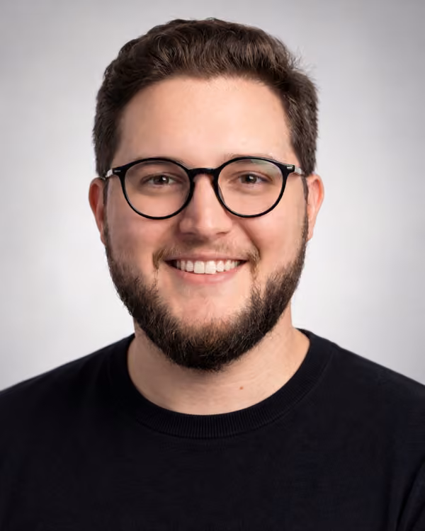 Retrato profissional de Henrique Gonçalves, com óculos pretos e barba