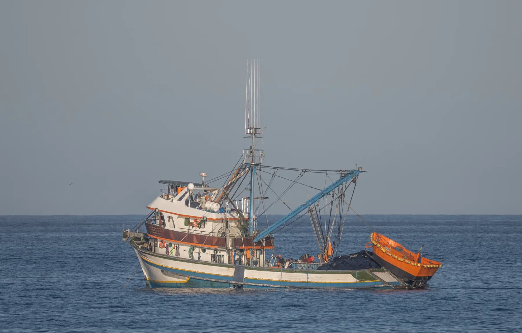 Fotografia editorial de uma embarcação pesqueira brasileira ao largo de Cabo Frio, como referência visual ao setor